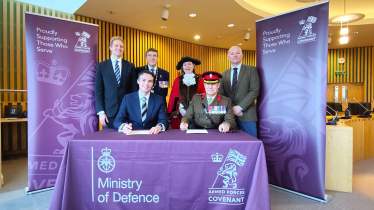 Cllr Tom Gracey signs the Armed Forces Covenant in front of the Mayor and MP